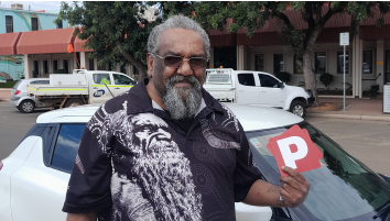 Edward holding his P Plates after passing his driving test.
