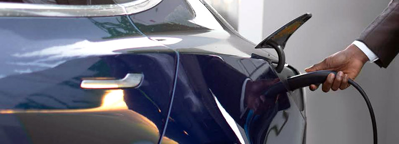 Driver charging an electric vehicle