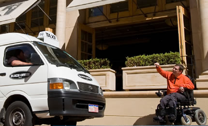 Man in a wheelchair hailing a taxi