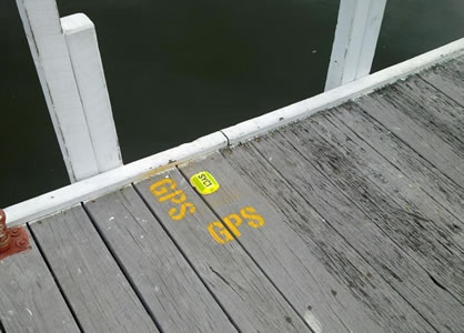 Yellow GPS marker on wooden jetty