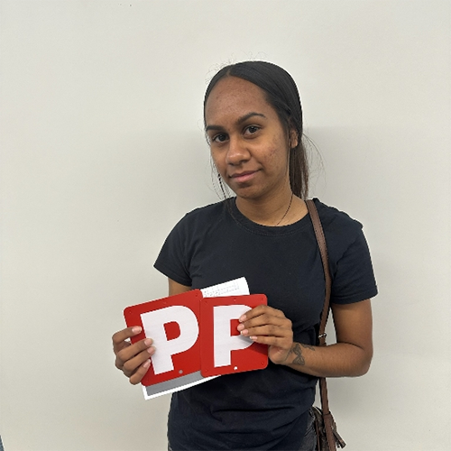 Ciara holding her P plates after passing her practical driving assessment